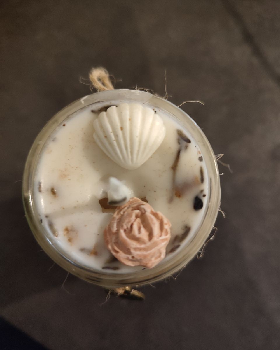 Bougie magique artisanale ornée d'un coquillage et de pétales de rose